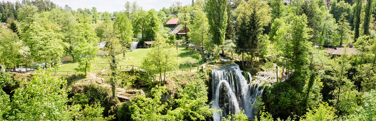 Fototapeta na wymiar panoramic photo of Village of Rastoke by a Korana river with wooden houses and a waterfall in Croatia.