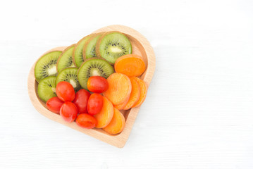 Diet and weight loss for healthy care, vegetable fruit and healthy food with dish shape heart on the old white wooden background top view. Healthy Concept.
