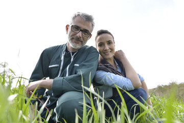 Portrait of happy couple of farmers in field