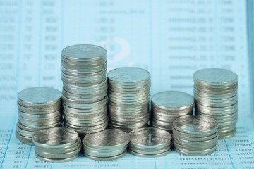 Step of coin stack with passbook or account book on wooden working table, savings and banking...