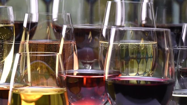 Champagne, white and red wines and drinks glasses on stained background