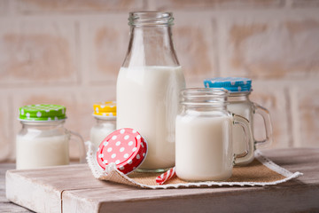 Milk jars with colorful caps on a cutting board 