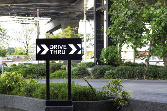 Drive thru sign with road background.
