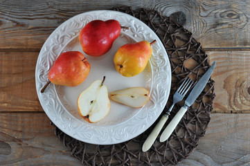 fresh whole and cut pears on plate