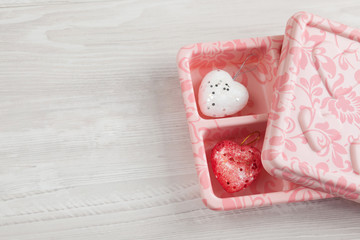 Woman take care Two hearts in gift box on wooden background. a red heart