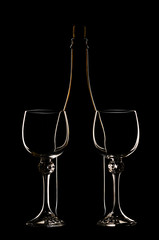 a contour of a bottle and glasses on a black background