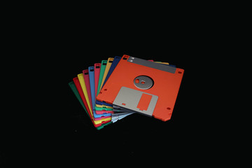 A stack of colorful floppy disks on the black background