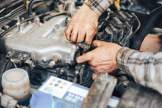 dirty hands of auto mechanic reparing car