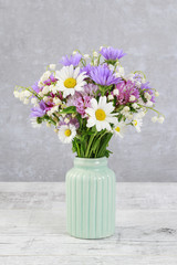 Cute bouquet of daisies, carnations, chamomile and lily of the valley flowers.