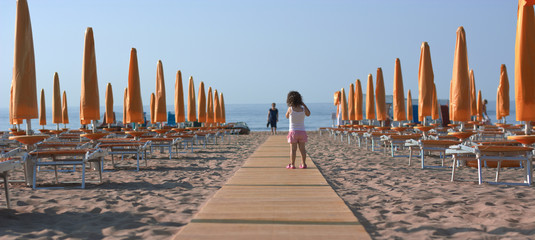 the small child got lost among the beach umbrellas