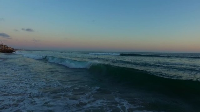 Slow low altitude evening flight over the beach and waves.