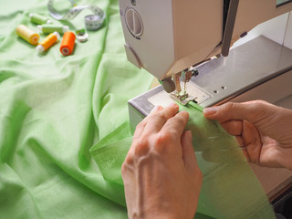 Seamstress works on a sewing machine. Stages of the production cycle on a sewing machine.