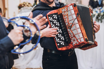 musicians playing on accordion and tambourine, musical band performing at wedding reception. fun...