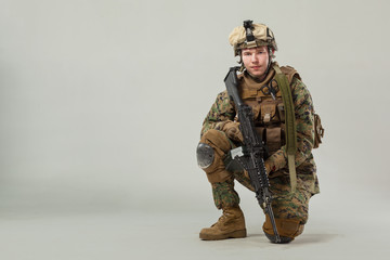 Soldier in camouflage holding rifle