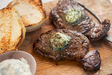 Angus steaks with garlic butter on barbecue with salad and dips. Barbecue party 