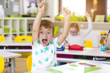 At School - Beautiful young kids have fun in school while learning in classroom