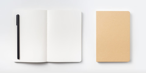 Design concept - Top view of hardcover kraft notebook and ballpoint pen isolated on white...