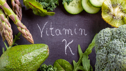 Green vegetables rich in vitamin K on black slate. - obrazy, fototapety, plakaty