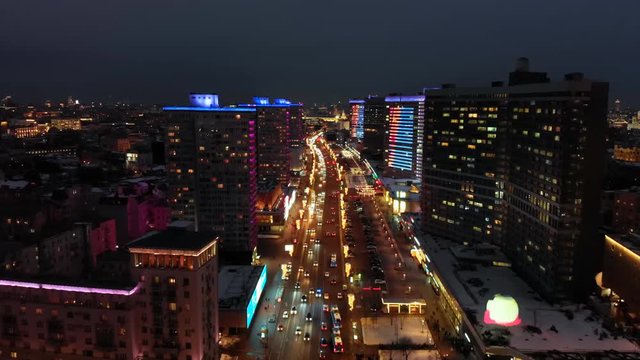 Bright lights of night Moscow from bird's eye view. Intensive traffic at New Arbat street in the heart of the city. Illuminated multistory houses on the sides of the wide avenue.