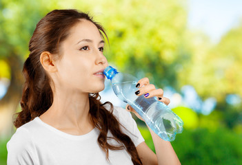 Beautiful smiling young woman holding a bottle of water