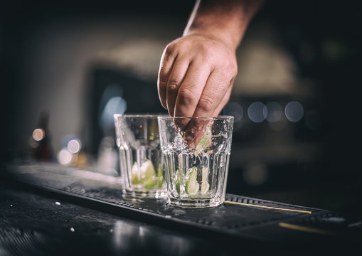 Barman hand squeezes lime juice