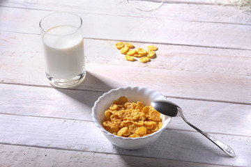 Corn Flakes cereal in a bowl and glass with milk. Morning breakfast.