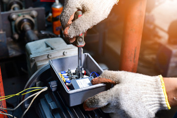 Electricians working on industrial panels, installing and assembling new wires.