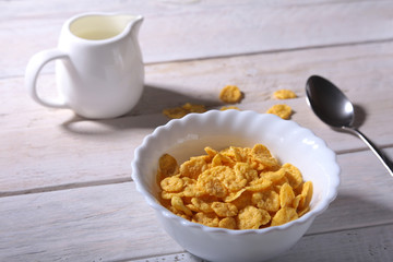 Corn Flakes cereal in a bowl and glass with milk. Morning breakfast.