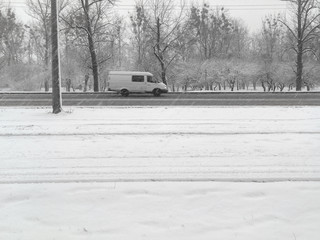 Snowfall. Snow cyclone. The streets of the city are covered with snow. Cars move around the snowy...