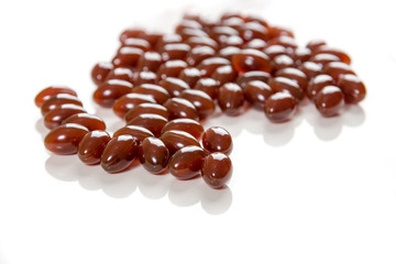 Capsules of brown color with lecithin on a white background. Biologically active additives.