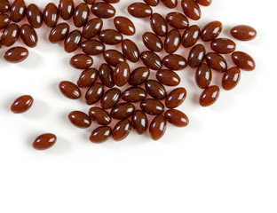 Capsules of brown color with lecithin on a white background. Biologically active additives.