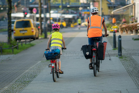 Fototapeta Mother and daughter cycling, rear view