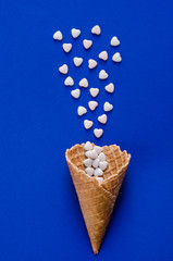 Ice Cream Cone Horn Hearts Sweethearts Candies. Flat lay Top View. Love,Valentines day concept. Summer Party, Birthday Firework Blue background. Bright Sweet Color. TrendyStyle.
