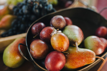 wedding rings are in the plate with fresh fruits