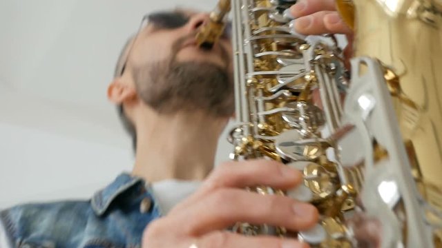 Man playing saxophone on white background. bottom view