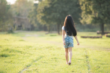 Fototapeta na wymiar Little girl running on meadow with sunset