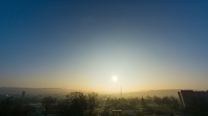 Sunrise at foggy morning in small city