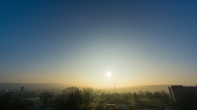 Sunrise at foggy morning in small city