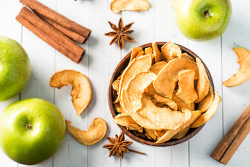 Dried apples in a wooden bowl Ripe green apples on the table