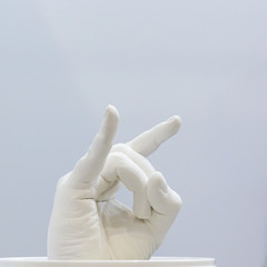 Brush hand from plaster on a blue background. Gesture of fingers in the form of a rock goat.