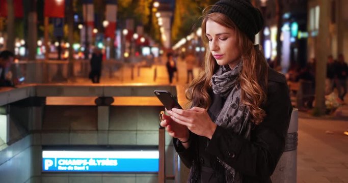 White woman in Paris trying to reach someone on phone on Champs-Elysees
