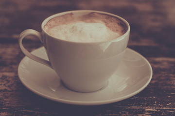 Coffee cup on table, vintage styled picture effect