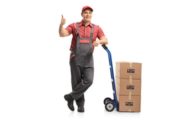 Mover leaning on a hand truck loaded with boxes making a thumb up gesture