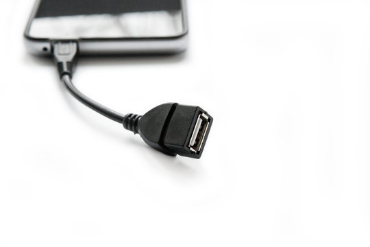 Adapter OTG USB - Micro USB connected to a smartphone on a white background.