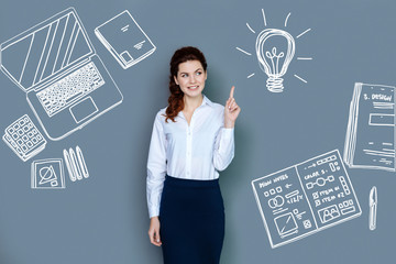 Having an idea. Positive young web developer feeling glad while getting a wonderful idea