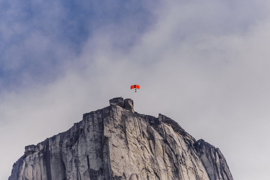 Person paragliding from mountain in the Tasermiut Fjord, Narsaq, Vestgronland, Greenland
