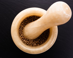 coriander seeds on a dark stone background, essential oil