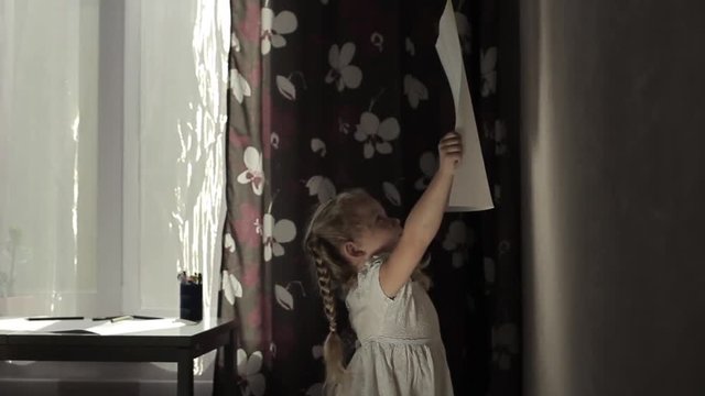 little girl brings picture to wall