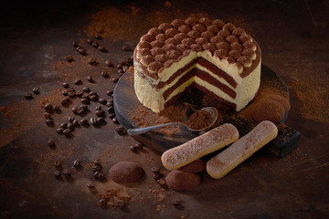Tiramisu cake on a dark slate,stone or metal background.