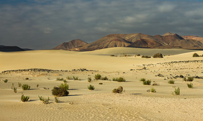 Sunrise over a volcano and sand dunes early morning on the canary island Fuerteventura 